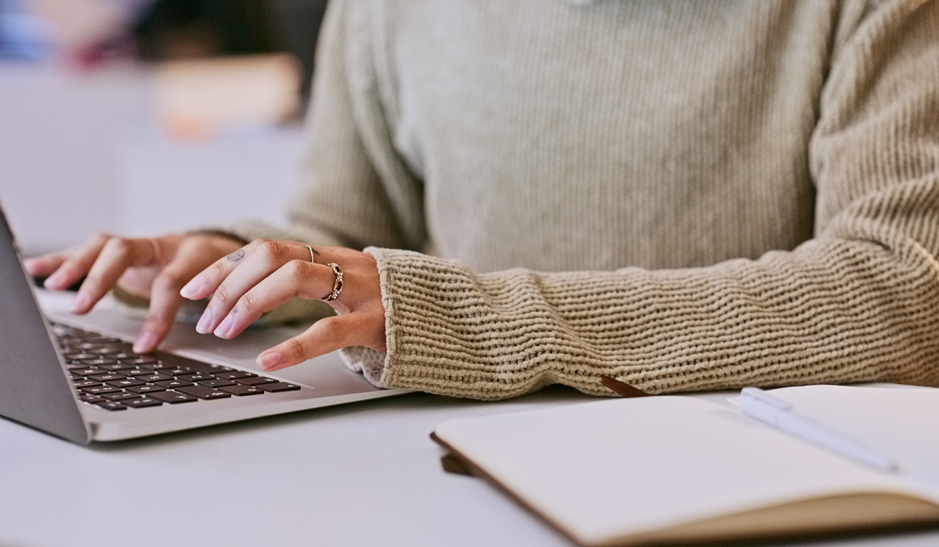 A student types an essay on her laptop.